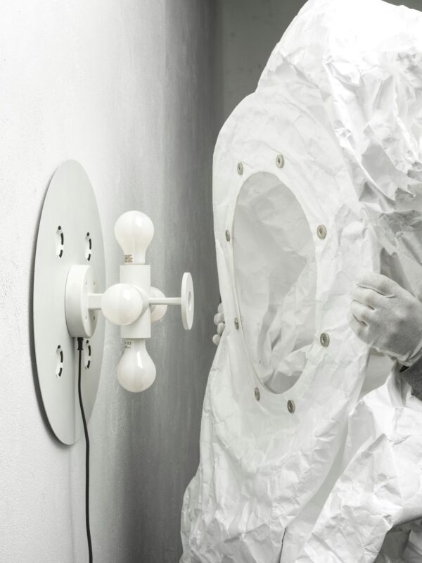 Persoană în costum protector lângă lampă modernă